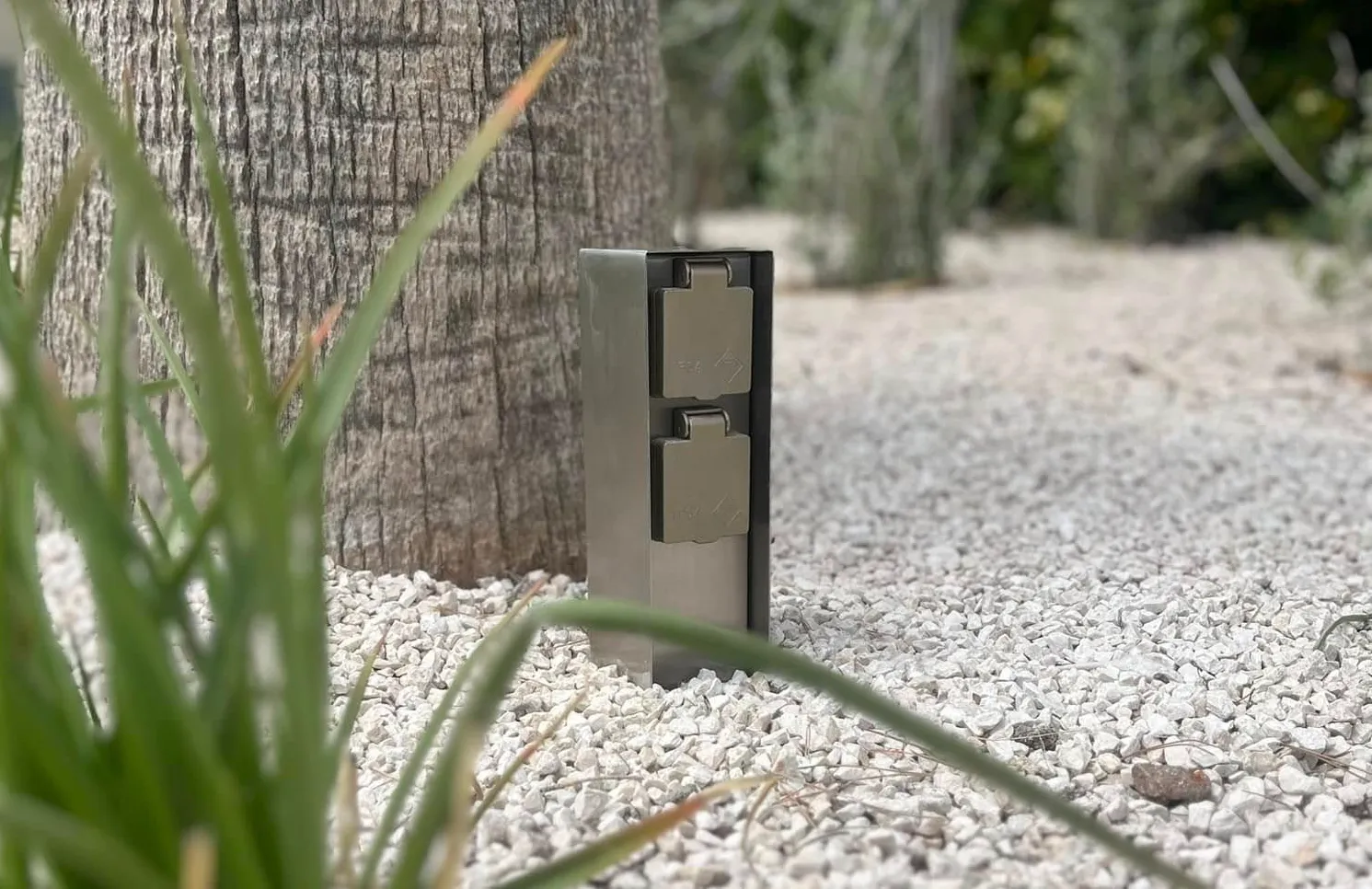 Prise de courant extérieure intégrée dans un aménagement paysager par T’Ohm Électricité